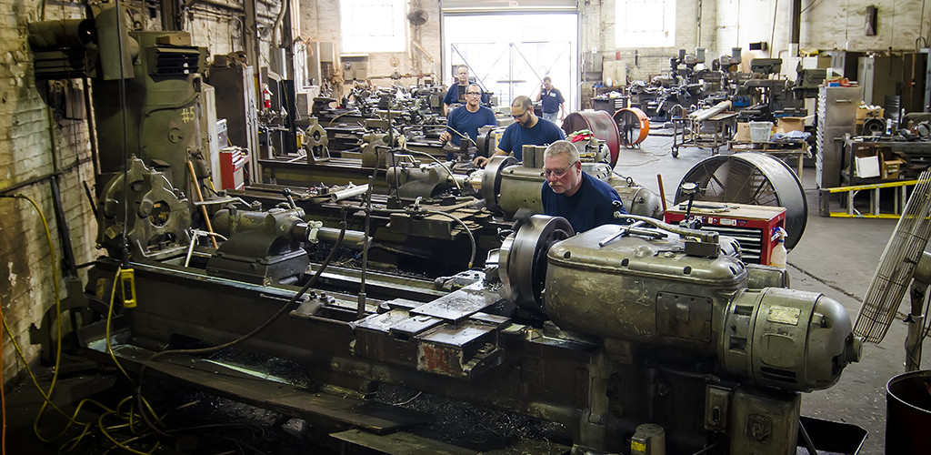 Multiple workers operating lathes